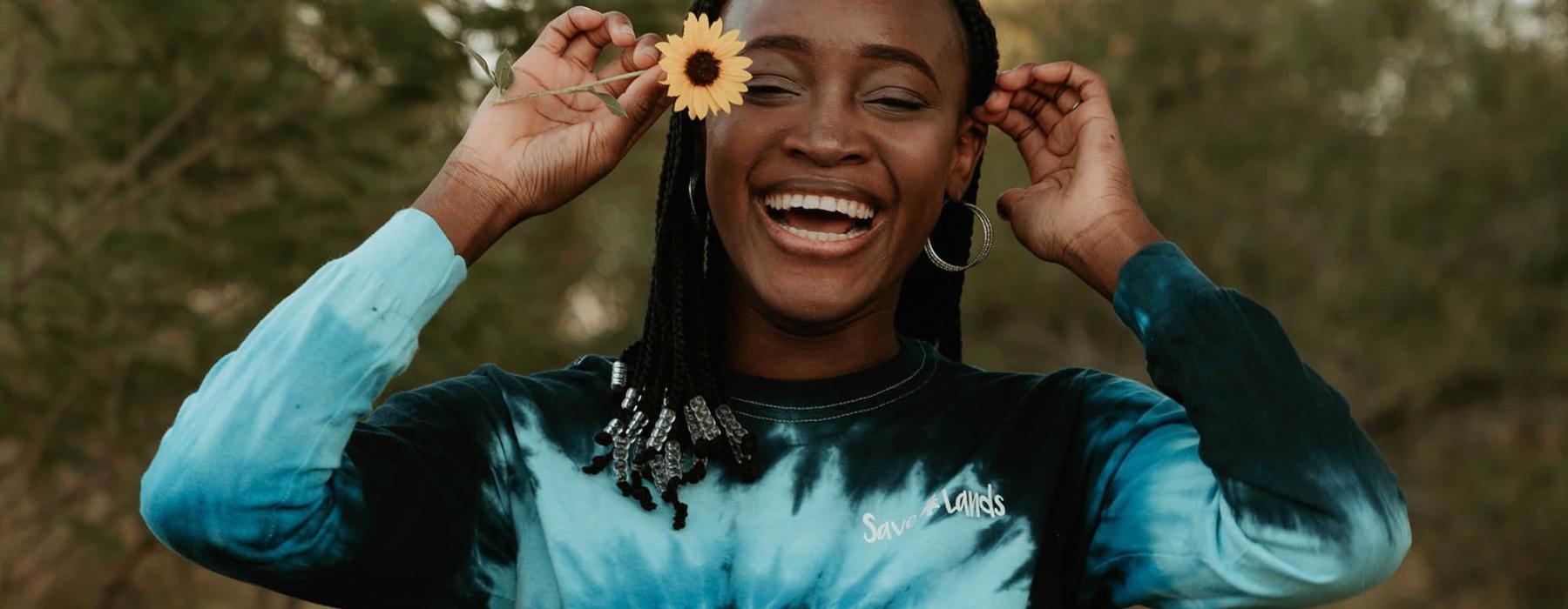 woman holds a flower in her hair in a park